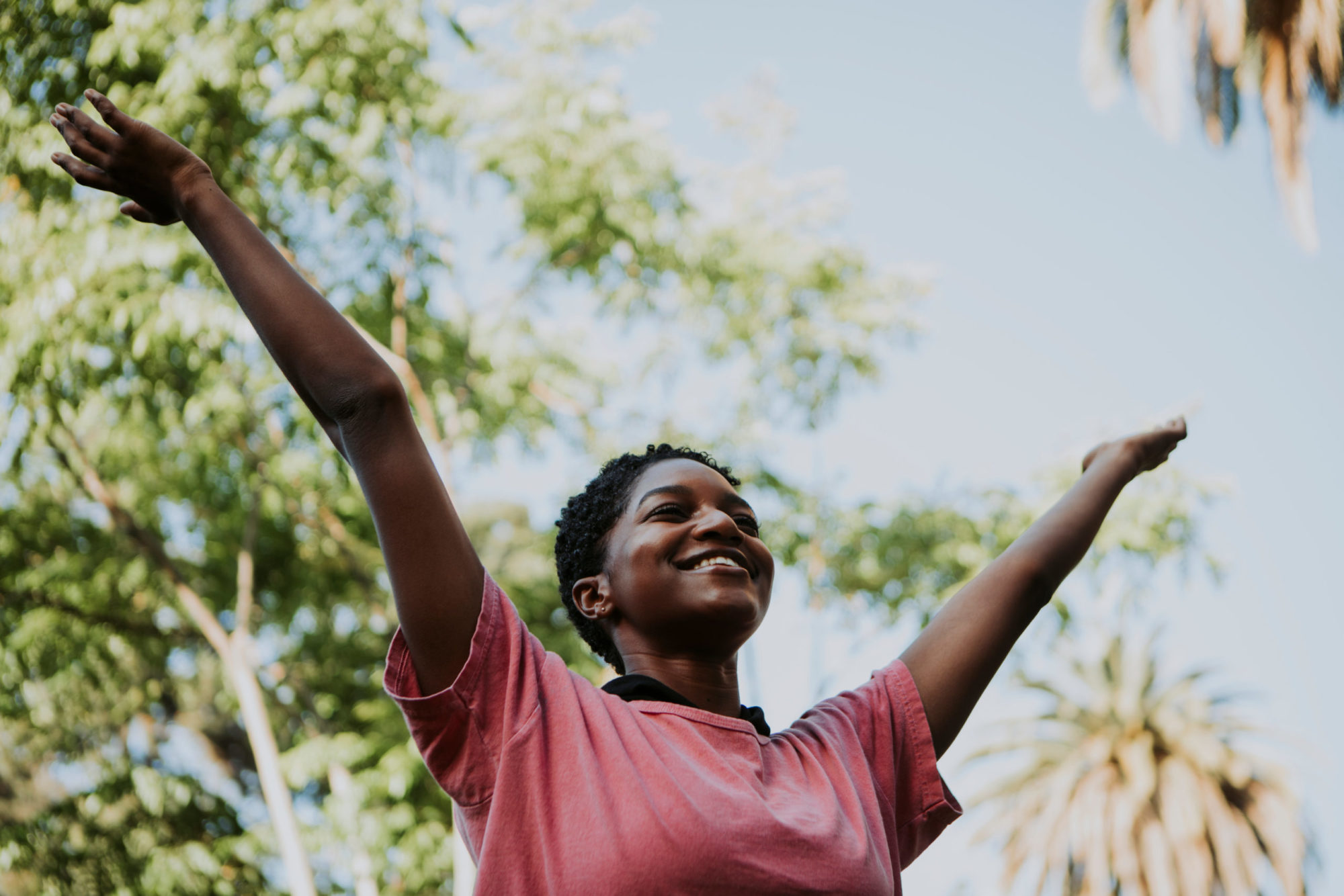 Happy woman feeling free in the park